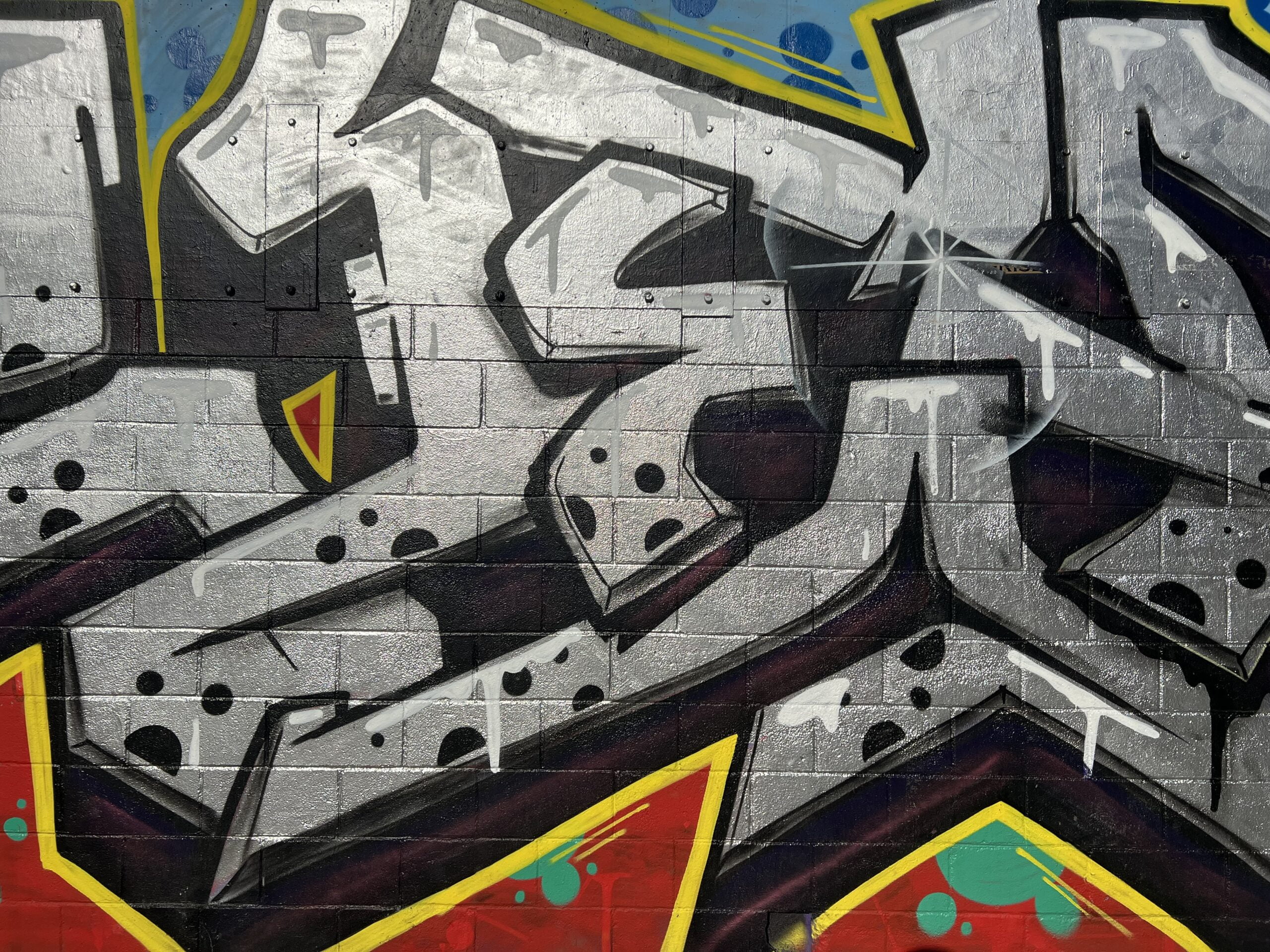 Urban graffiti art: Colorful expression on city walls, showcasing creativity on Carrer dels Tallers in Raval, Barcelona.